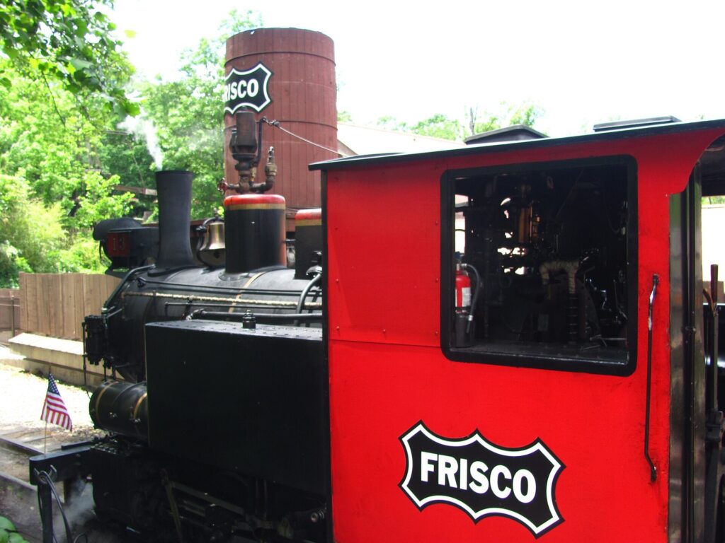 Black steam locomotive with a red cab marked Frisco at Silver Dollar City in Branson, Missouri