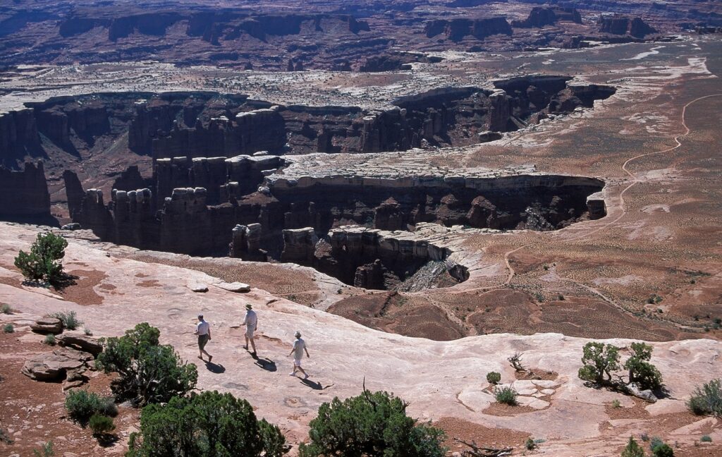 Hikers walking the rim at Grand View Point on Island in the Sky, Canyonlands National Park