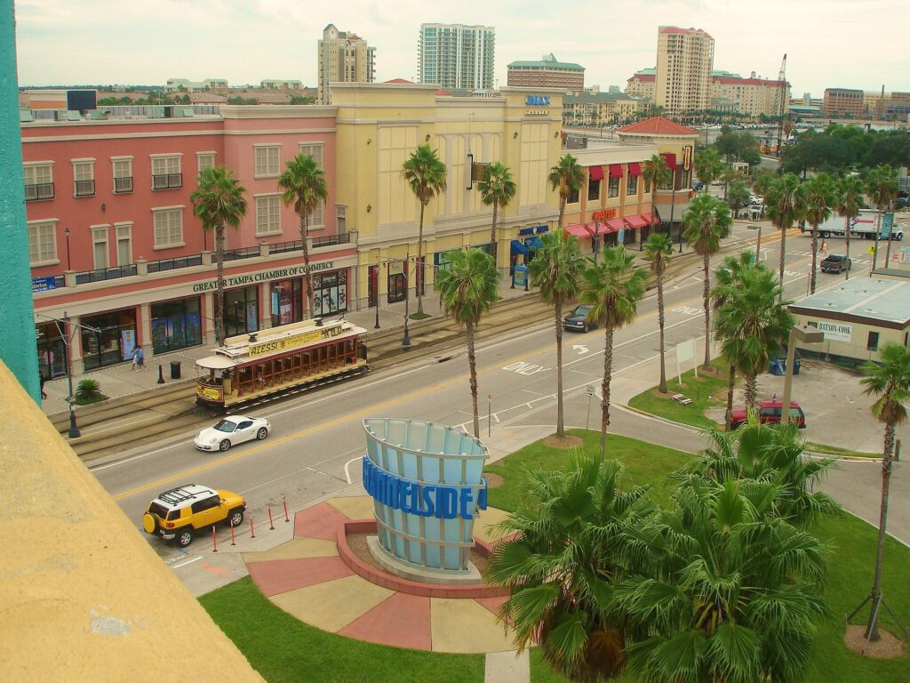 Channelside Drive in Tampa seen from a parking garage, with a streetcar and palm trees below