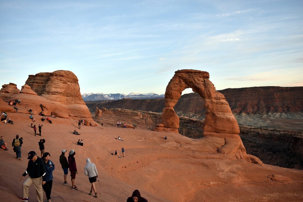 People gathered on the slickrock bowl near Delicate Arch at Arches National Park