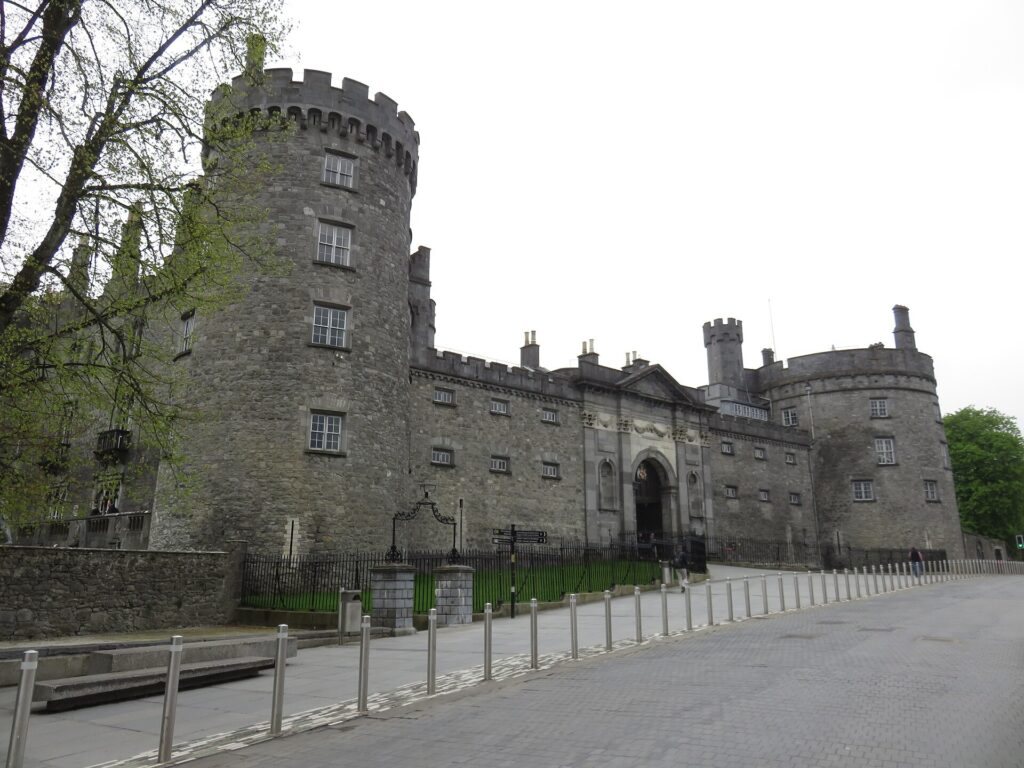 Kilkenny Castle stone towers and gatehouse beside the road in Kilkenny