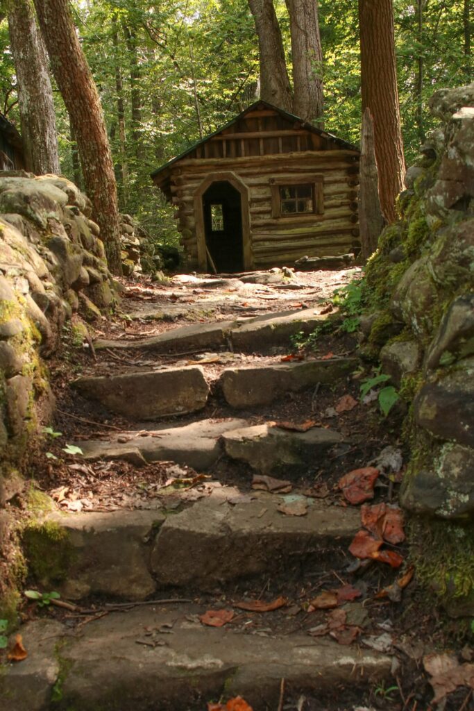 Stone steps climbing to a small log cabin among trees in the Elkmont area of Great Smoky Mountains National Park