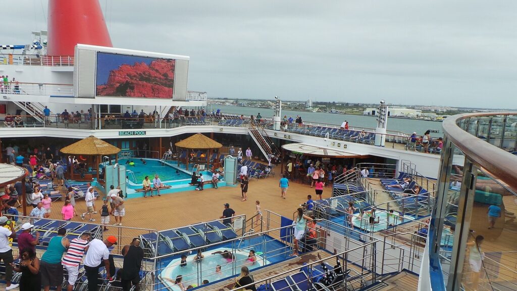 Beach Pool on the Lido Deck of the Carnival Sunshine cruise ship with lounge chairs and passengers