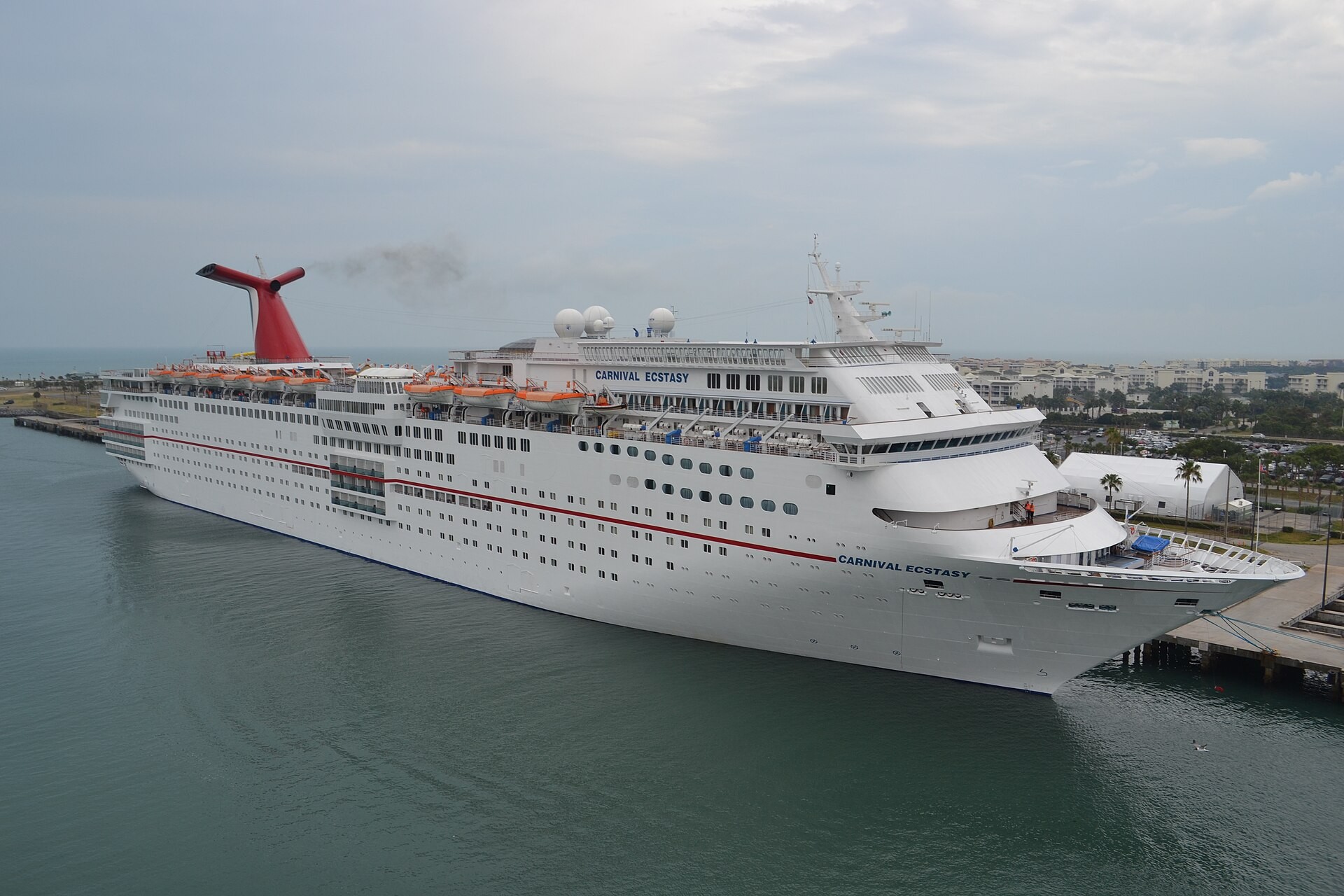 A Carnival cruise ship docked at Port Canaveral, Florida, with the terminal pier alongside