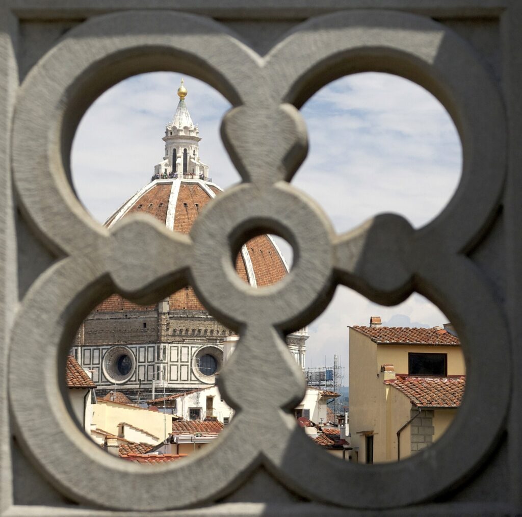 Florence cathedral dome seen through a carved stone window opening