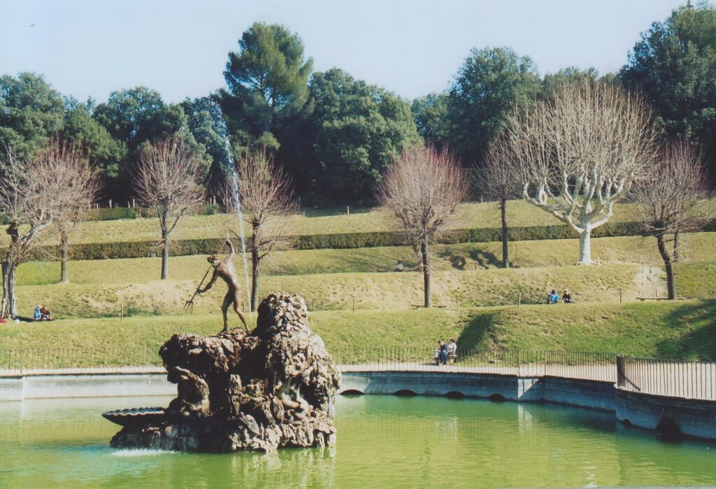Sculpted fountain in a green pond in the Boboli Gardens in Florence