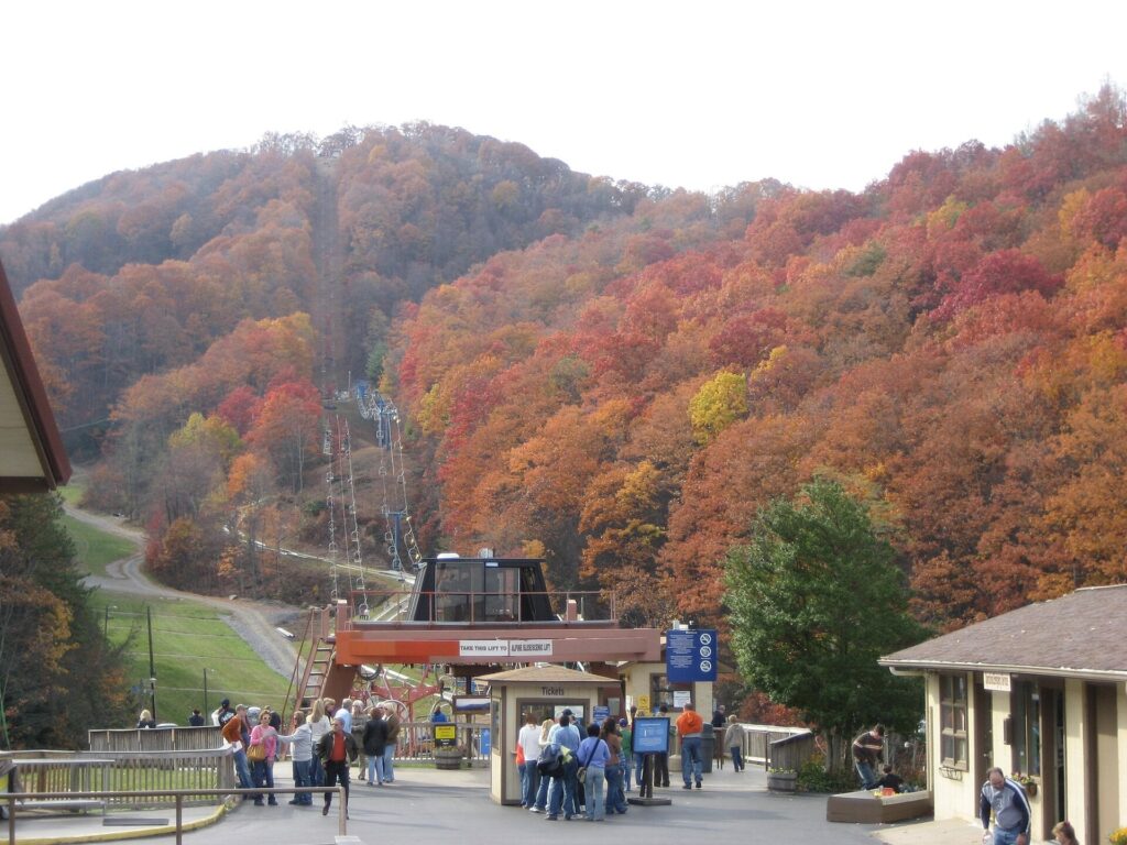 Autumn-colored hillside above Ober Gatlinburg with visitors near the lower station