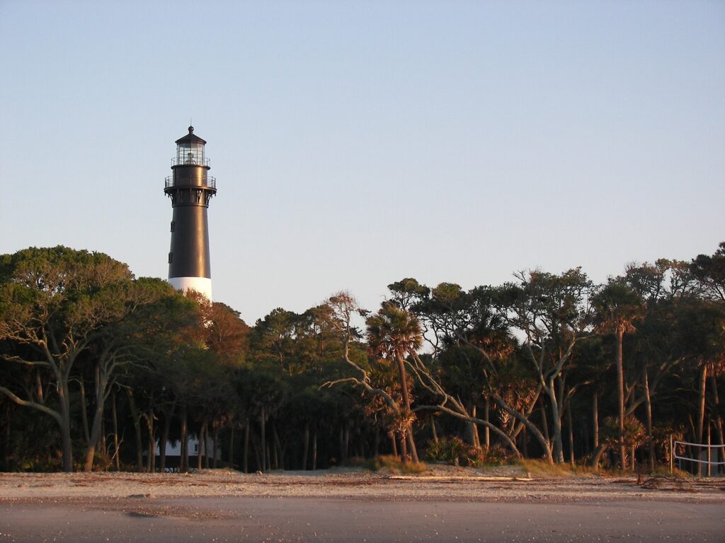 Black-and-white Hunting Island Lighthouse rising over trees at Hunting Island State Park, South Carolina