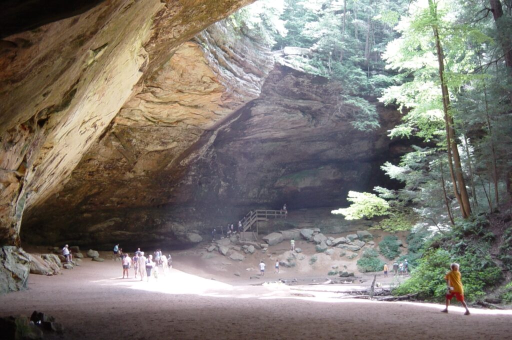 Wide sandstone recess of Ash Cave with a few visitors below, Hocking Hills State Park, Ohio