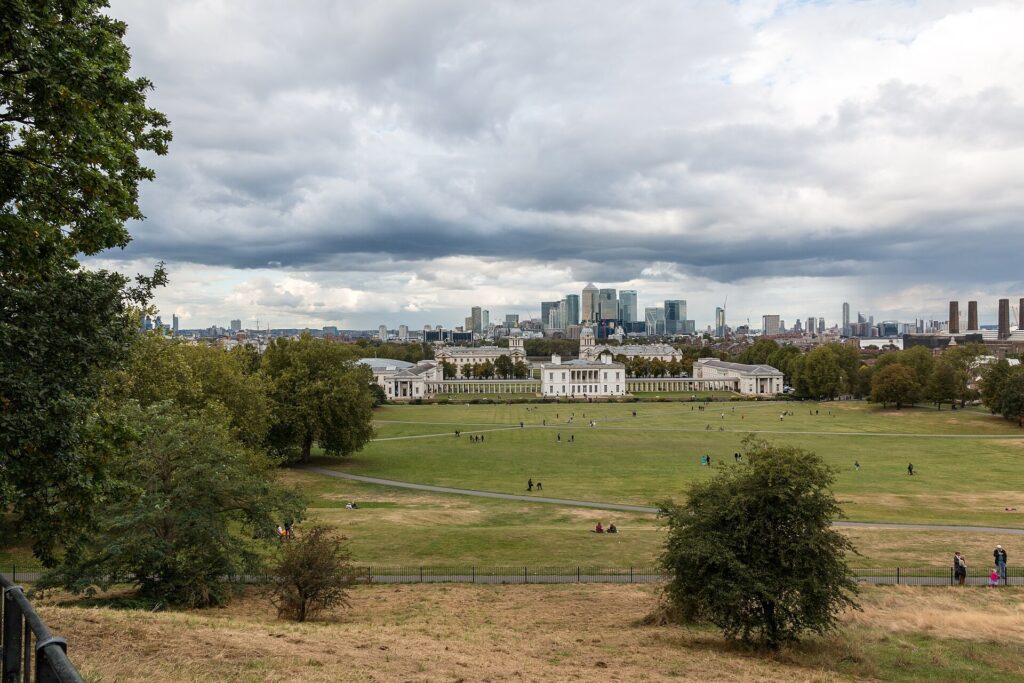 Greenwich Park lawn with the Canary Wharf skyline beyond, London
