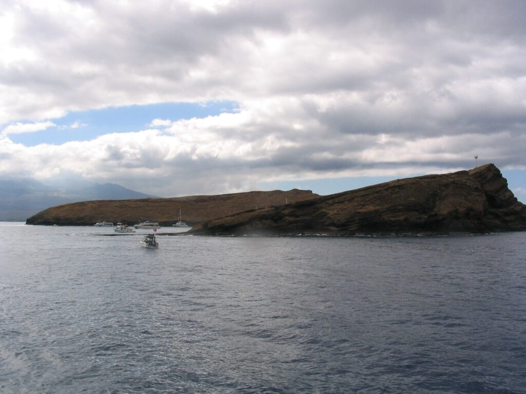 Crescent-shaped Molokini islet rising from blue water off Maui
