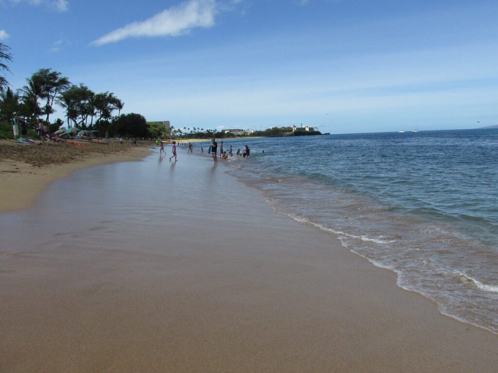 Wide sandy stretch of Kaanapali Beach on Maui with calm shallow water