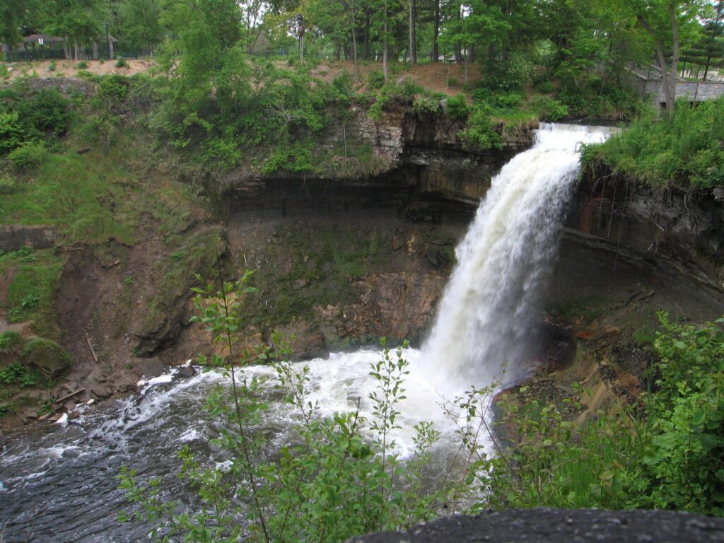 Minnehaha Falls tumbling over a rock ledge into the creek below in Minneapolis