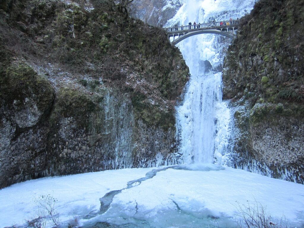 Multnomah Falls frozen in winter with the Benson Bridge spanning the gap above
