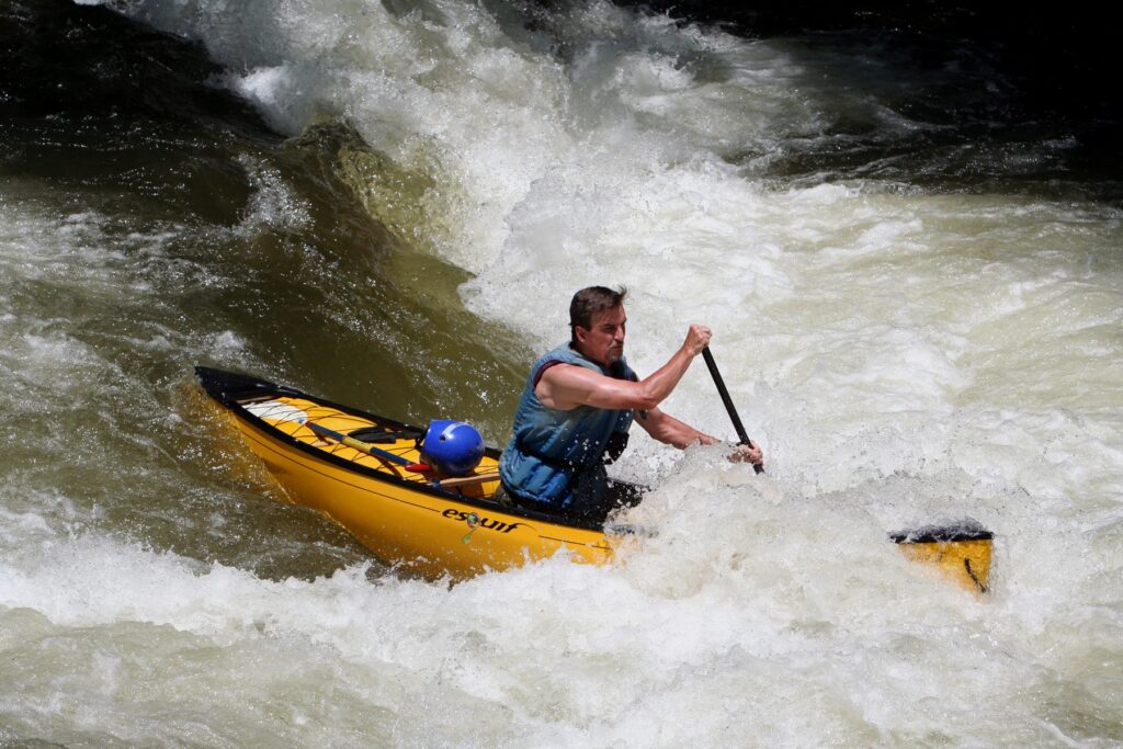 A canoeist paddling through a rapid on the Nantahala River in North Carolina