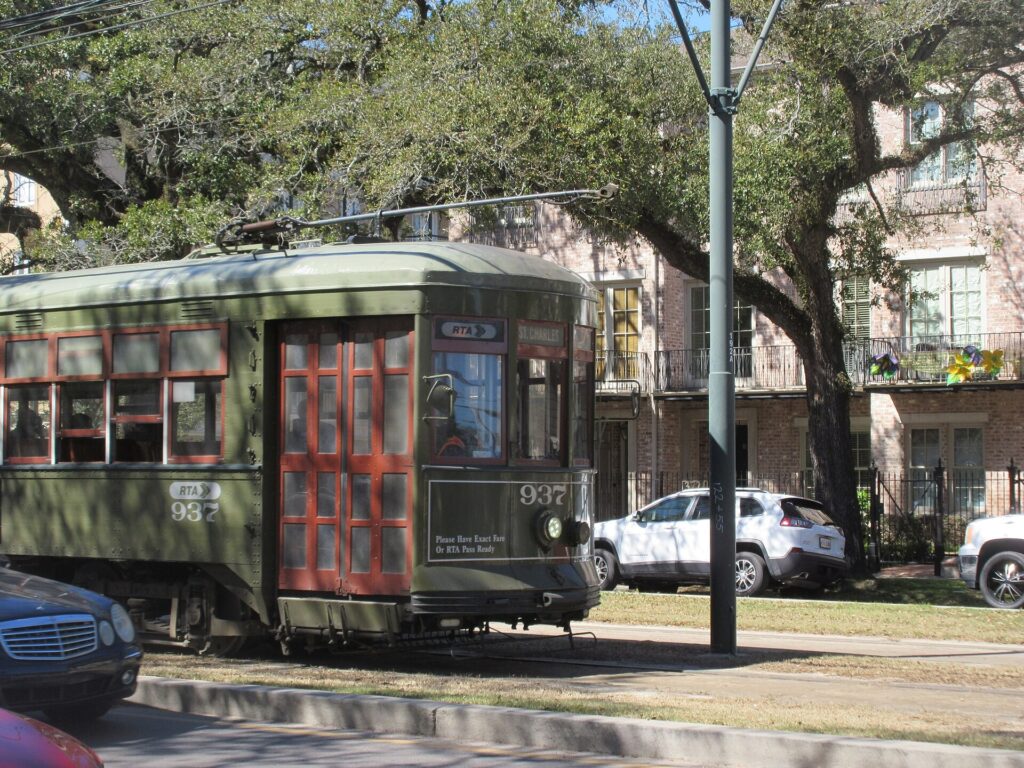 Green streetcar passing under oak trees on St. Charles Avenue in Uptown New Orleans