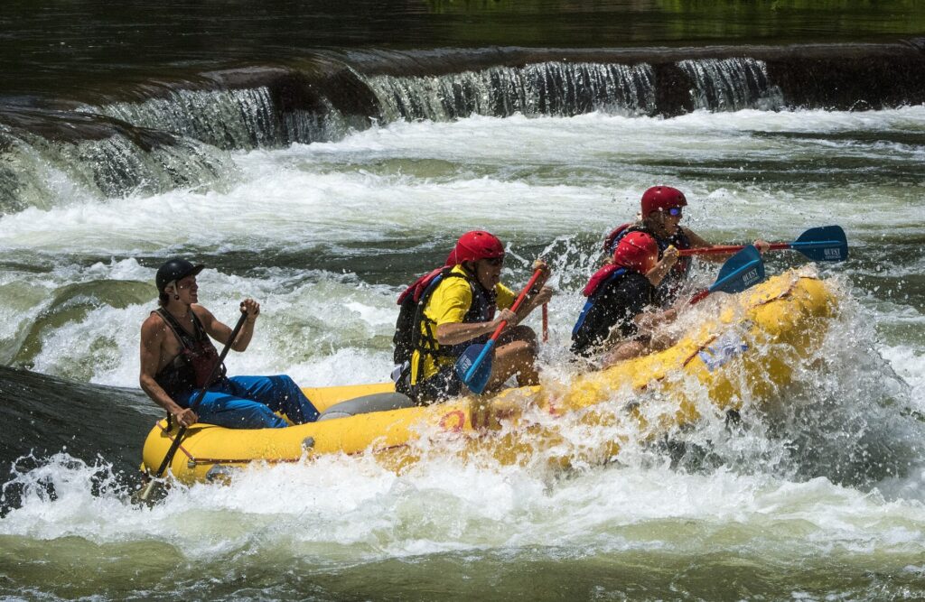 A raft crew paddling below a ledge of whitewater on the Ocoee River in Tennessee