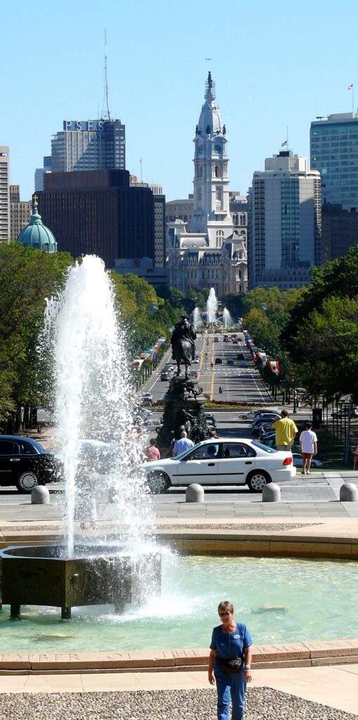 Fountain beside Benjamin Franklin Parkway with a tall tower in the distance