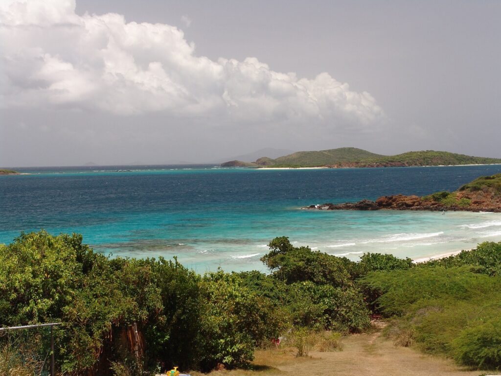 Turquoise water, green hills and a sandy path down to a beach on Culebra, Puerto Rico