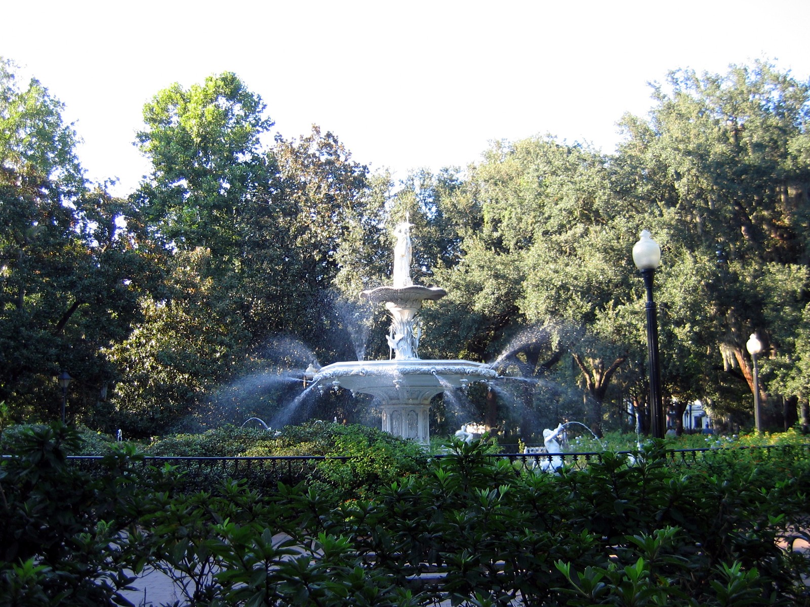 White fountain in Forsyth Park, Savannah, with oaks and walkway around it