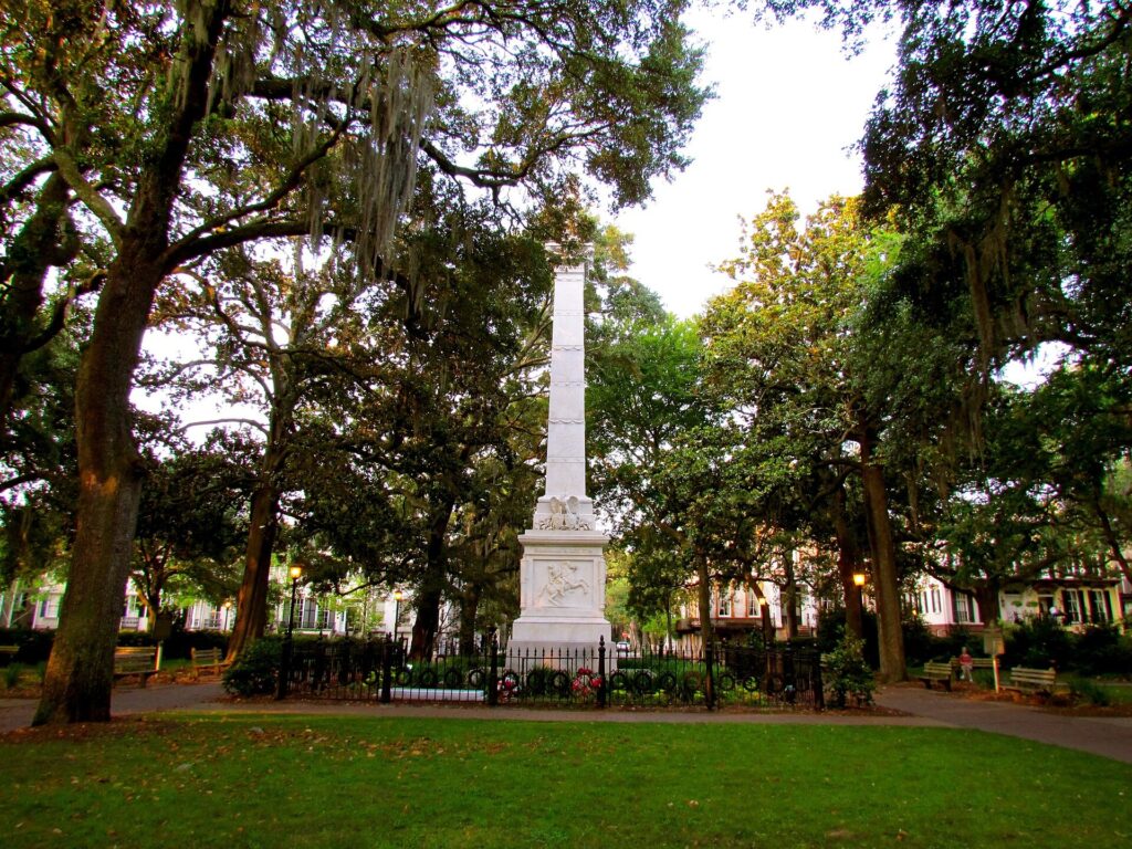 Obelisk monument on the lawn of a shaded Savannah square with oaks around it