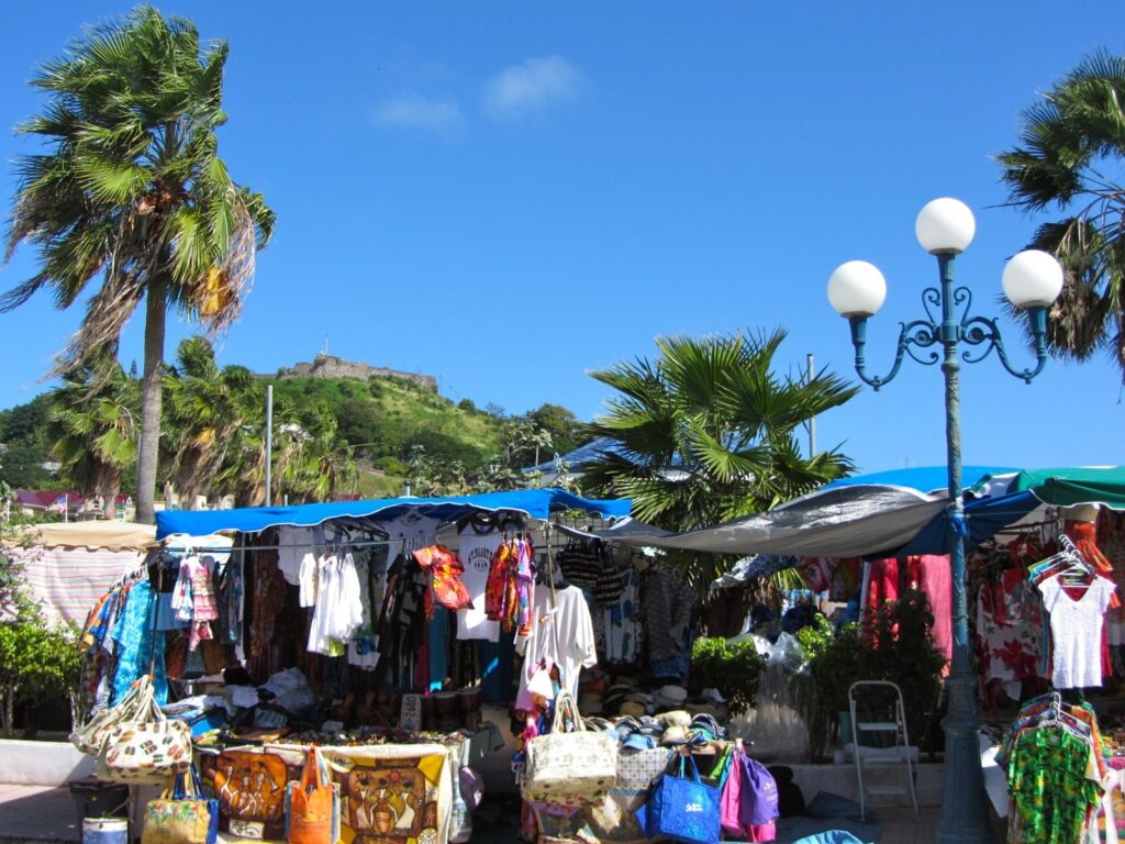 Clothing and craft stalls under canopies at the Marigot waterfront market in Saint-Martin