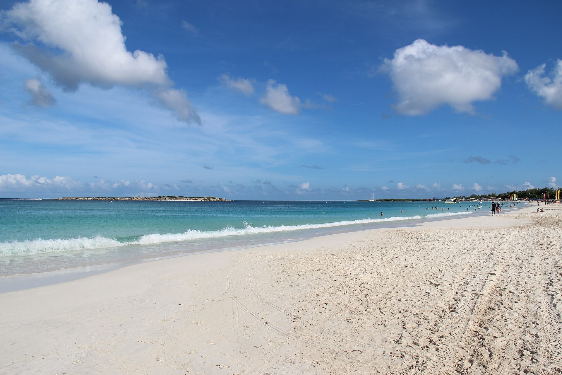 Wide sandy beach with turquoise water and small waves at Orient Bay on the French side of St. Maarten