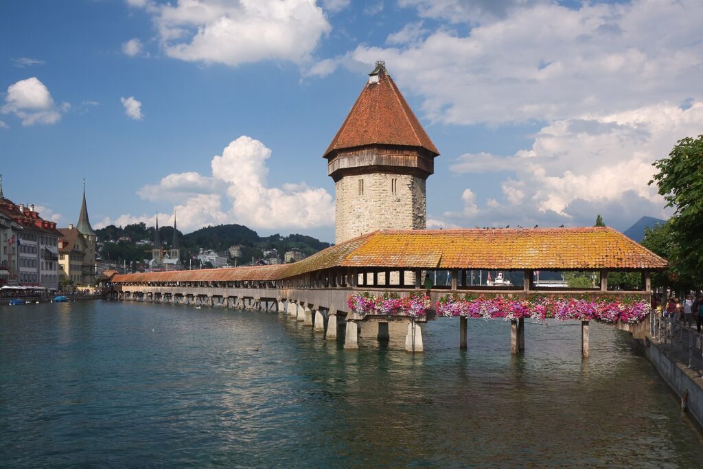 The covered wooden Chapel Bridge and its stone water tower across the Reuss river in Lucerne, Switzerland