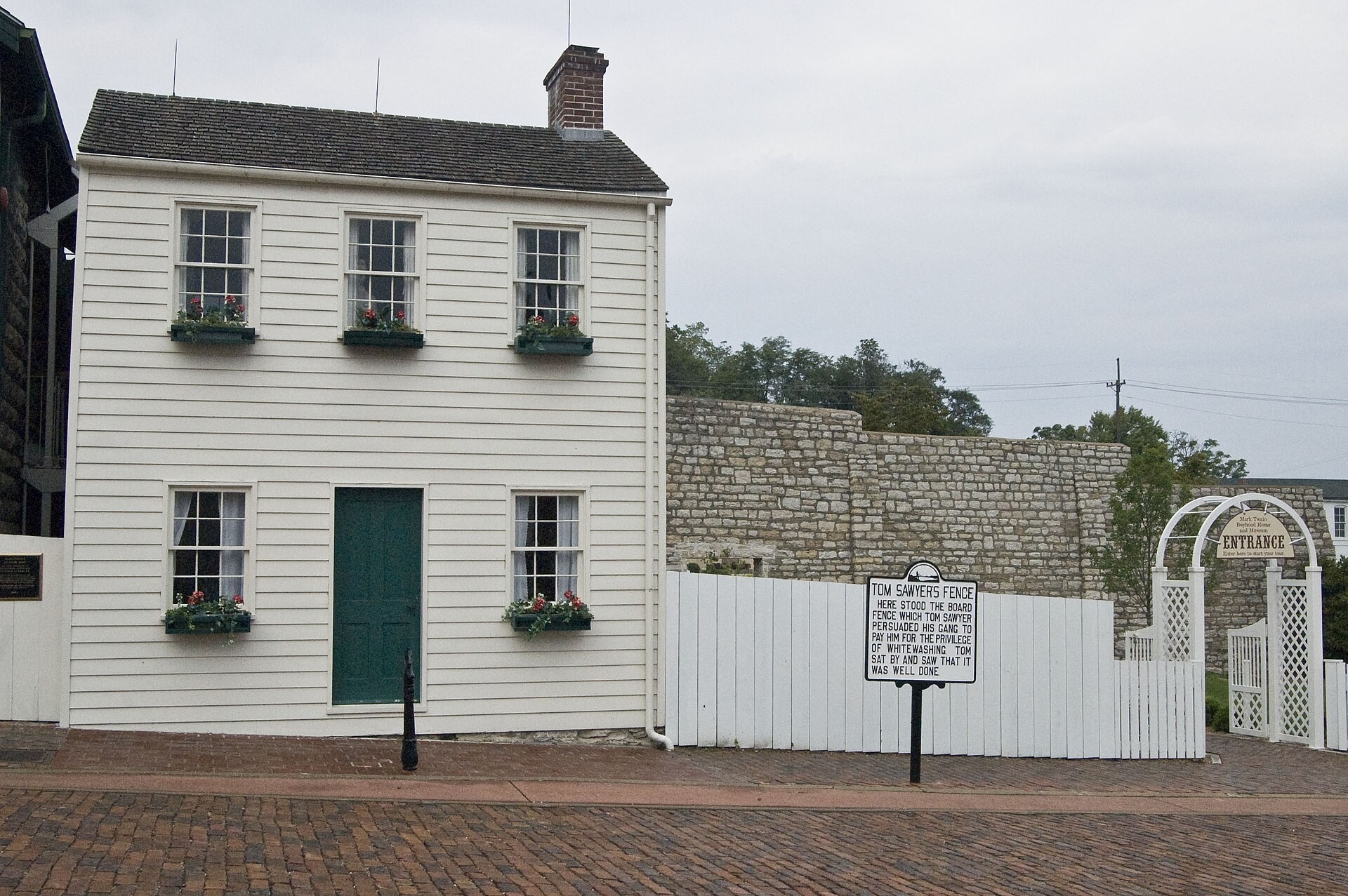 Mark Twain's boyhood home, a white clapboard house with flower boxes and a green door, in Hannibal, Missouri
