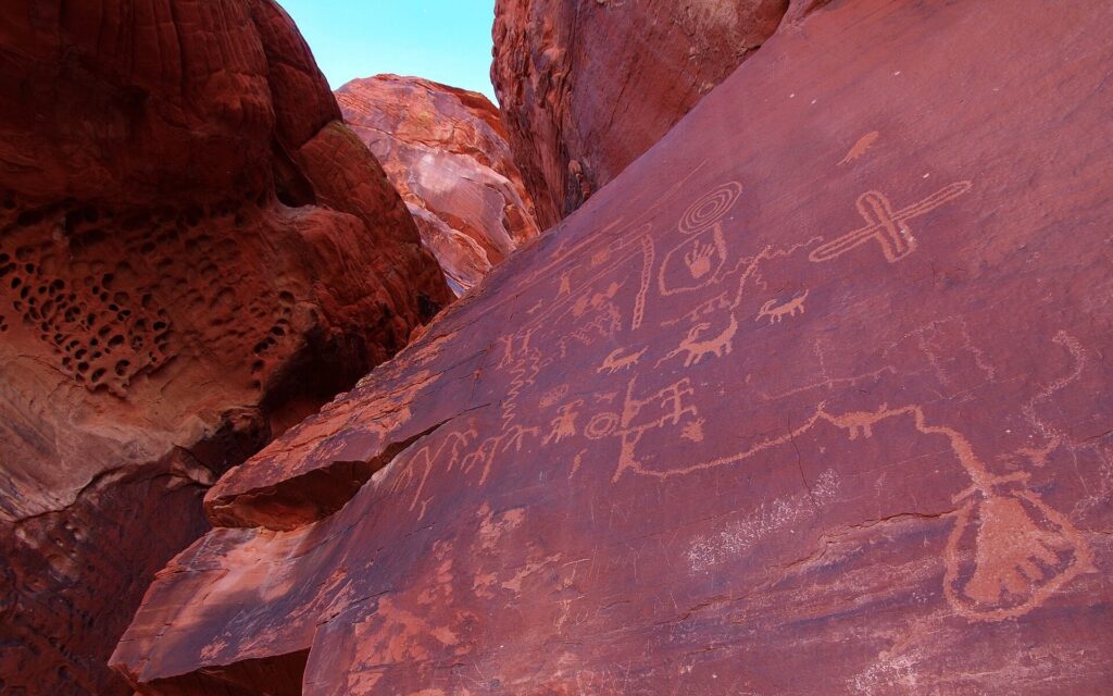 Ancient petroglyphs carved into a red rock wall at Atlatl Rock, Valley of Fire State Park