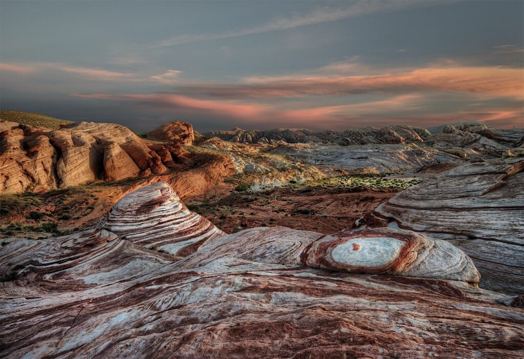 Banded red and white sandstone under a colorful sunset sky in Valley of Fire State Park