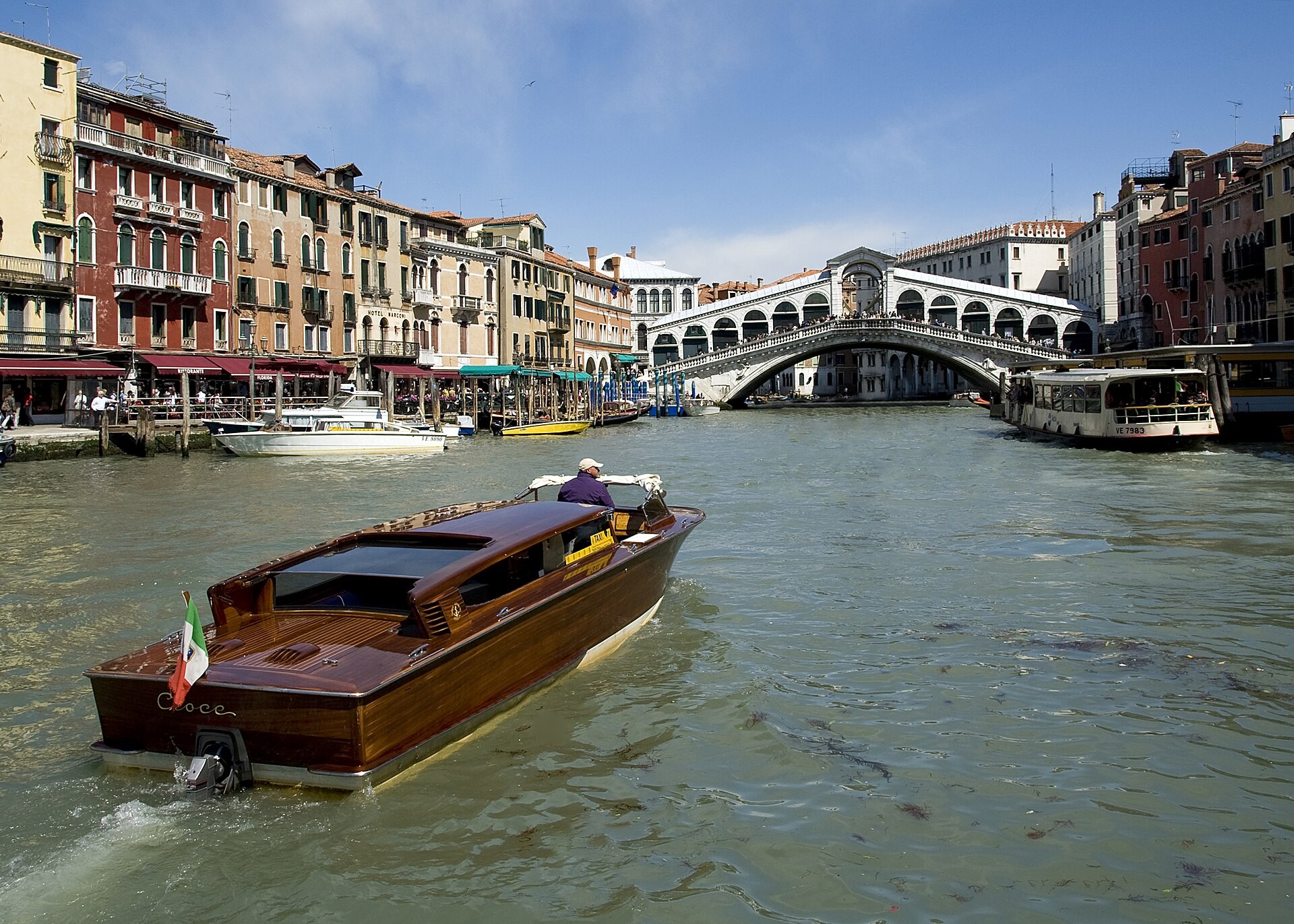 The Rialto Bridge arching over the Grand Canal in Venice, with boats on the water