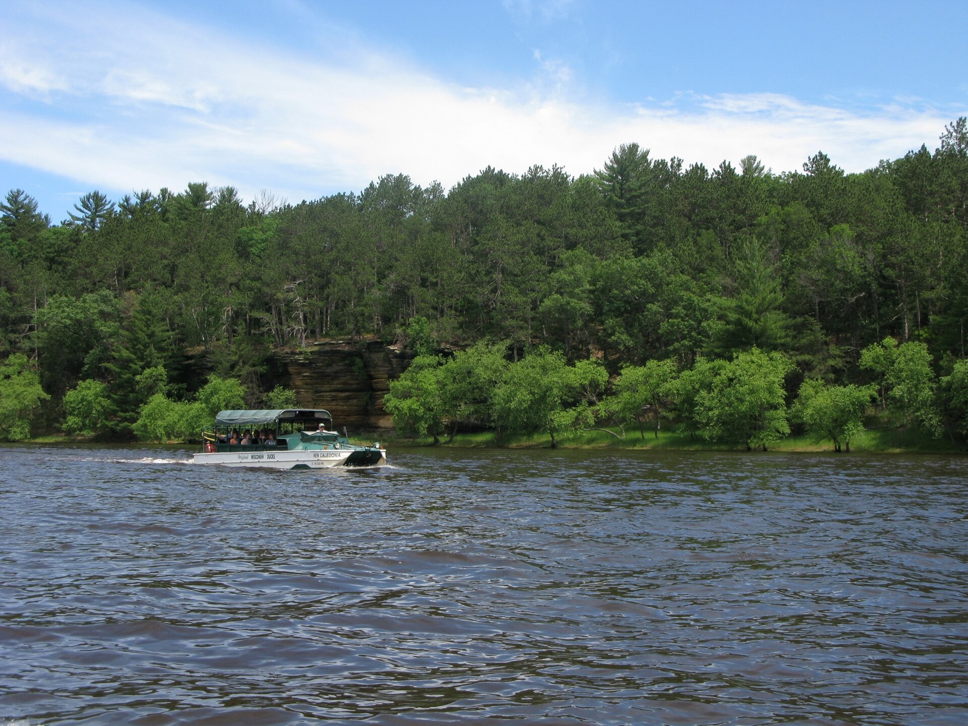 Tour boat on the Wisconsin River below wooded bluffs in Wisconsin Dells